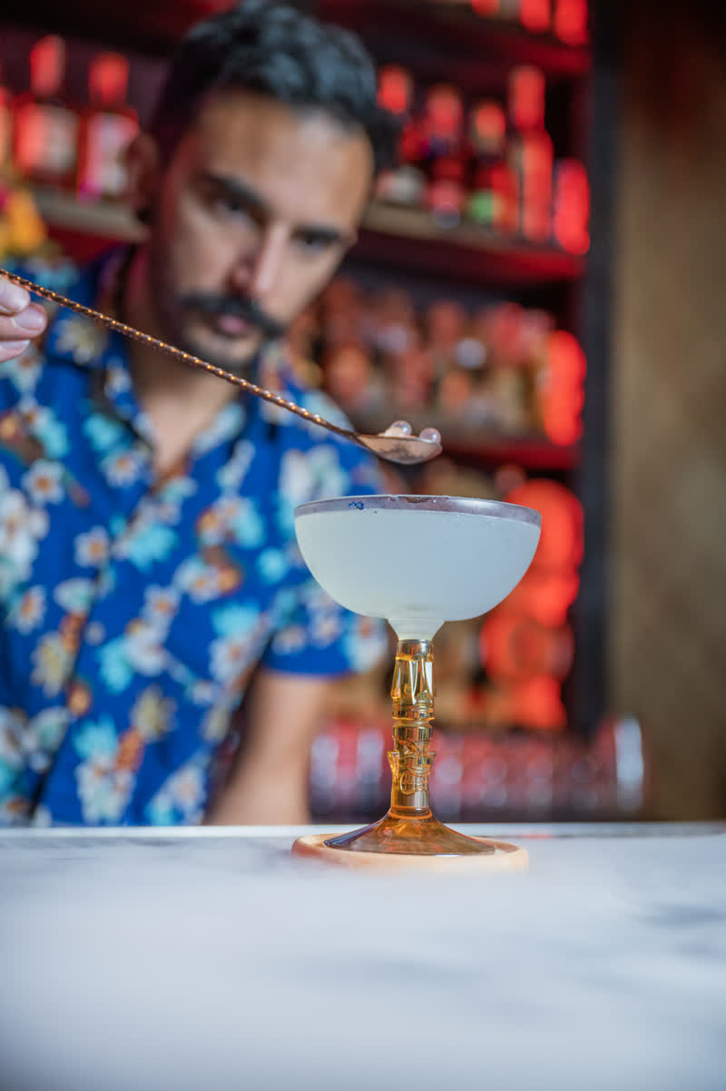 Bartender carefully garnishing a craft cocktail at Kaona Room