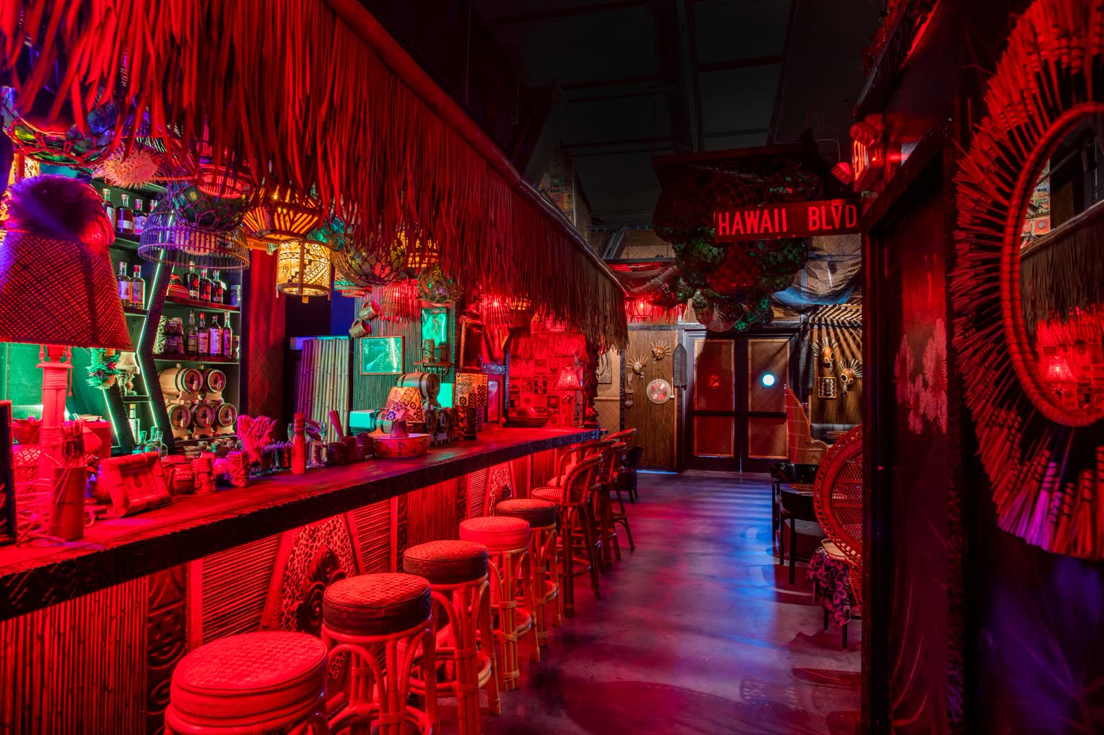Inside Kaona Room - Miami's hidden tiki speakeasy bar with bamboo stools and red ambient lighting